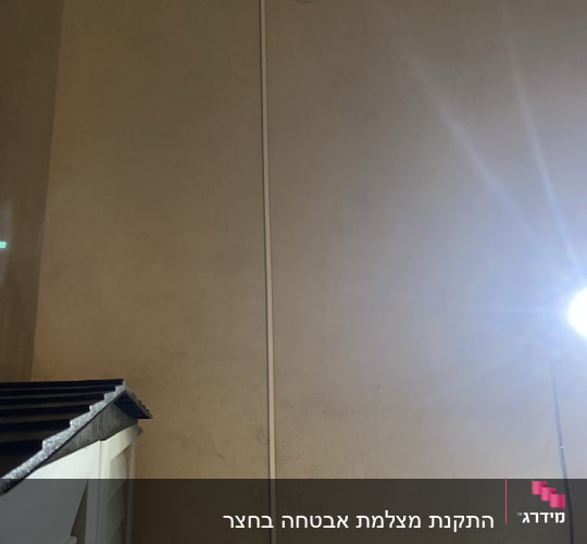 מצלמת אבטחה מותקנת על קיר עם כבל חשמל